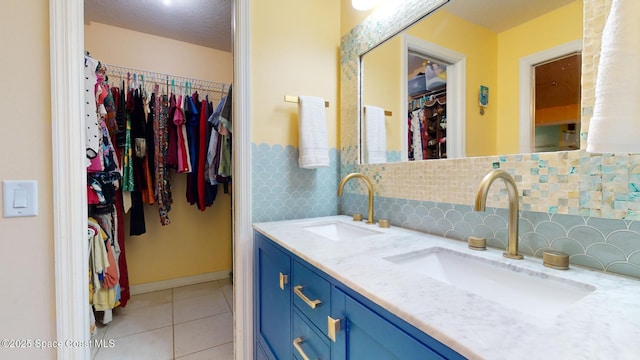 bathroom featuring decorative backsplash, tile patterned floors, vanity, and a textured ceiling