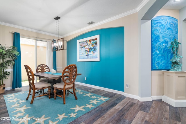 dining area with crown molding, dark hardwood / wood-style floors, and a notable chandelier