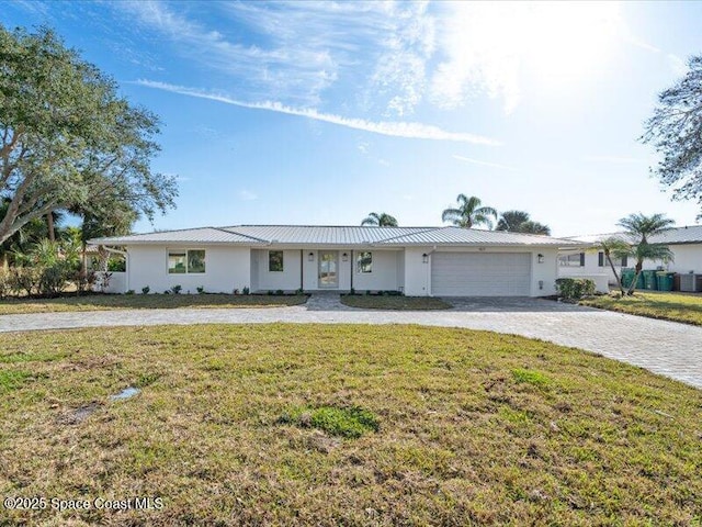 ranch-style house featuring a garage and a front lawn