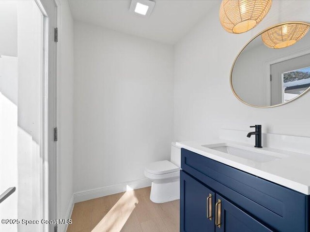 bathroom with vanity, toilet, and wood-type flooring