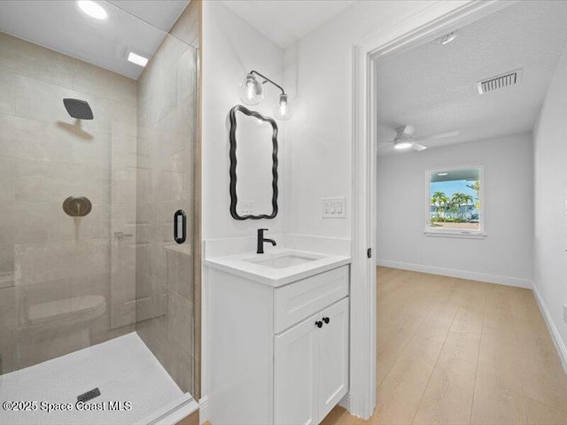 bathroom with vanity, hardwood / wood-style floors, a shower with door, and toilet