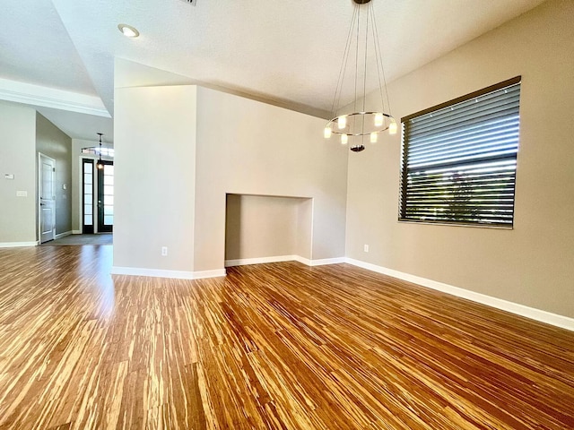 spare room featuring hardwood / wood-style flooring, plenty of natural light, and a chandelier