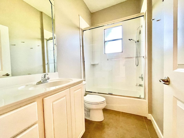 full bathroom featuring vanity, tile patterned flooring, shower / bath combination with glass door, and toilet