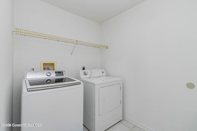 washroom with washing machine and dryer and light tile patterned floors