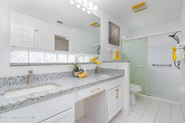 bathroom featuring vanity, toilet, a shower with shower door, and tile patterned flooring