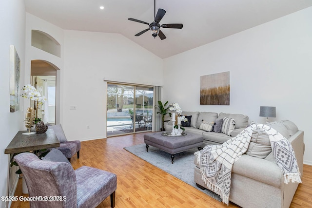 living room with wood-type flooring, high vaulted ceiling, and ceiling fan