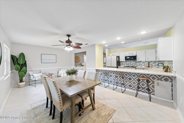 dining space featuring ceiling fan and light tile patterned floors