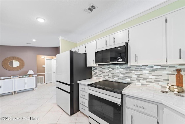 kitchen with white cabinetry, refrigerator, light tile patterned floors, electric range, and backsplash