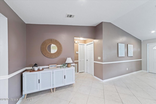 interior space featuring lofted ceiling and tile patterned flooring