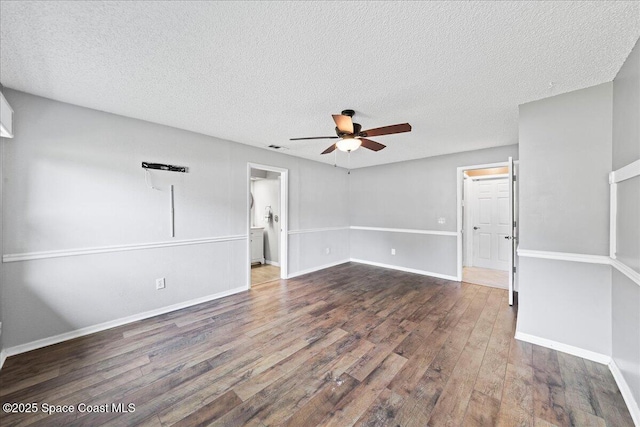 empty room featuring dark wood-type flooring, a textured ceiling, and ceiling fan