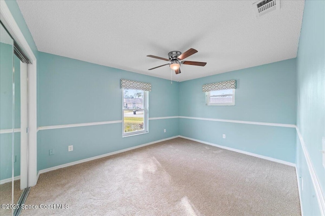 empty room featuring carpet and a textured ceiling