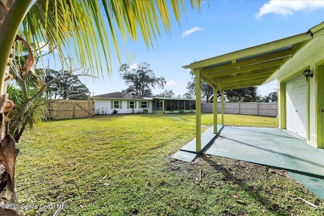 view of yard featuring a garage and a sunroom