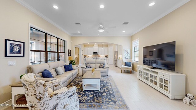 living room featuring recessed lighting, visible vents, arched walkways, and crown molding