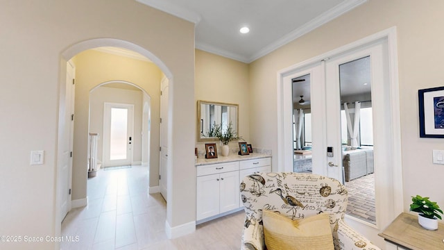 hall with baseboards, ornamental molding, recessed lighting, french doors, and arched walkways