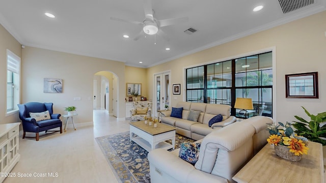 living room with recessed lighting, visible vents, arched walkways, and ornamental molding