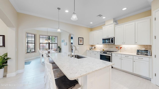 kitchen with visible vents, backsplash, appliances with stainless steel finishes, and a sink