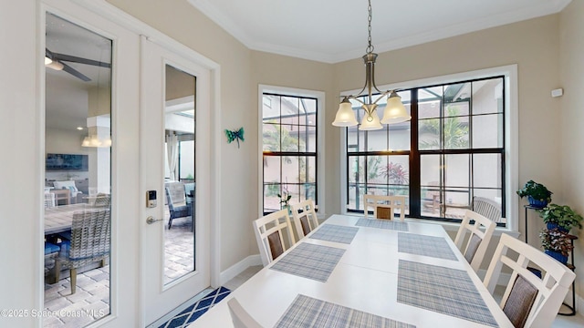 dining area with french doors, baseboards, an inviting chandelier, and crown molding