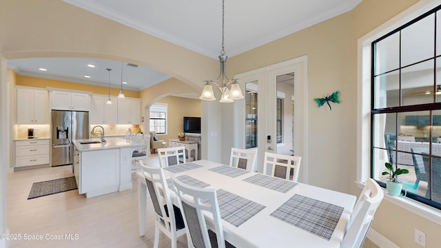 dining space with recessed lighting, arched walkways, crown molding, baseboards, and a chandelier