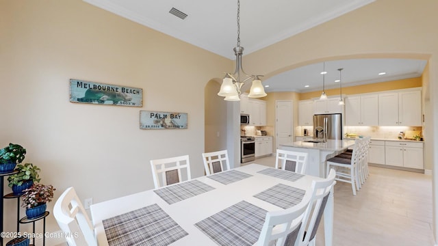 dining room featuring recessed lighting, visible vents, arched walkways, and crown molding