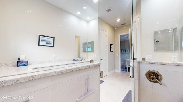 full bathroom featuring visible vents, baseboards, recessed lighting, tiled shower, and vanity