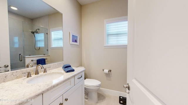 bathroom with baseboards, vanity, toilet, and a shower stall