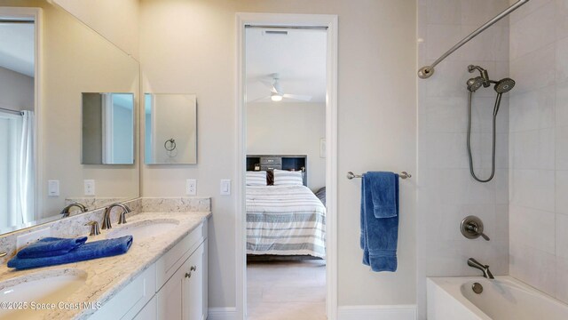 bathroom with a sink, connected bathroom, washtub / shower combination, and double vanity