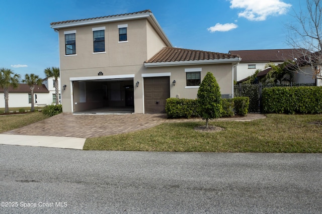 view of front of home with decorative driveway, a front lawn, stucco siding, and a tiled roof