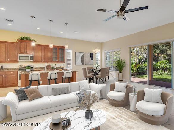 living room with ceiling fan with notable chandelier