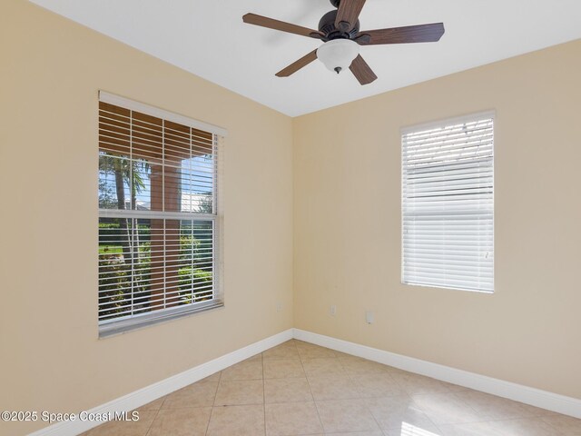 tiled spare room with ceiling fan and a healthy amount of sunlight