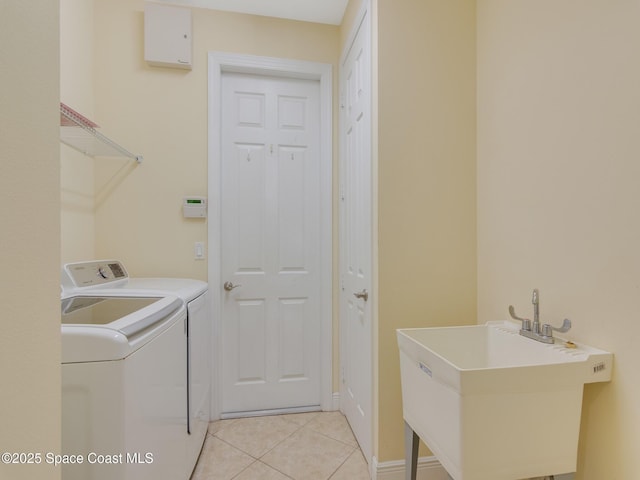 laundry room with washing machine and dryer, sink, and light tile patterned floors