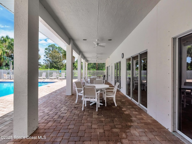 view of patio featuring ceiling fan and a fenced in pool