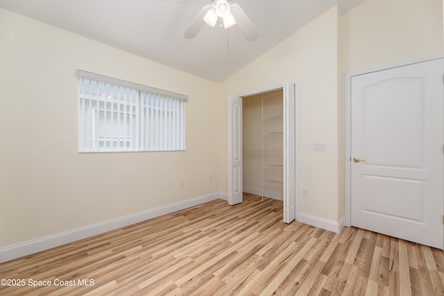 unfurnished bedroom with ceiling fan, lofted ceiling, light wood-type flooring, and a closet