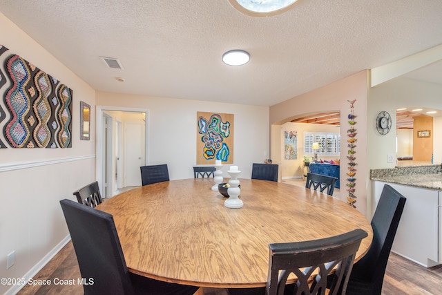 dining space featuring hardwood / wood-style floors and a textured ceiling