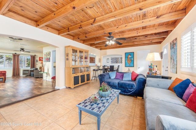 living room with ceiling fan, wooden ceiling, beamed ceiling, and light tile patterned flooring