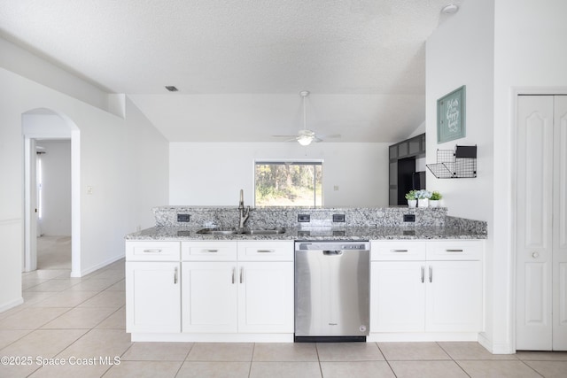 kitchen with white cabinetry, stainless steel dishwasher, vaulted ceiling, and sink