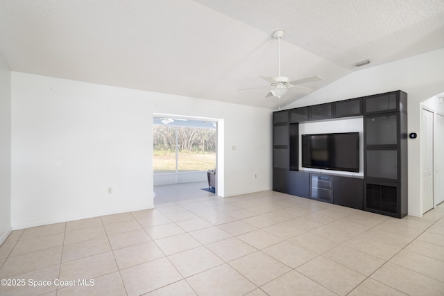 unfurnished living room featuring lofted ceiling, light tile patterned floors, a textured ceiling, and ceiling fan