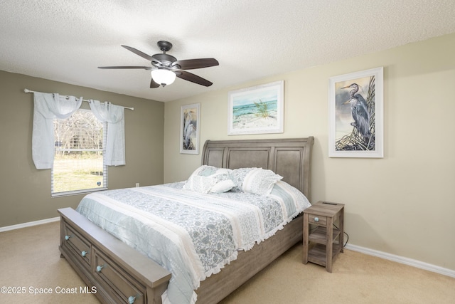 bedroom featuring light carpet, a textured ceiling, and ceiling fan