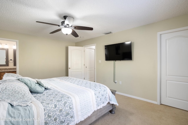 carpeted bedroom featuring ceiling fan, connected bathroom, and a textured ceiling