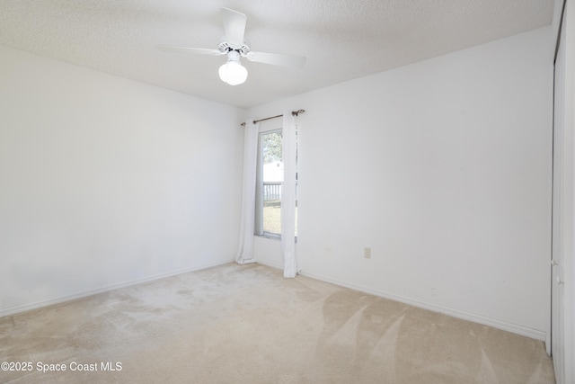 unfurnished room featuring light carpet, ceiling fan, and a textured ceiling