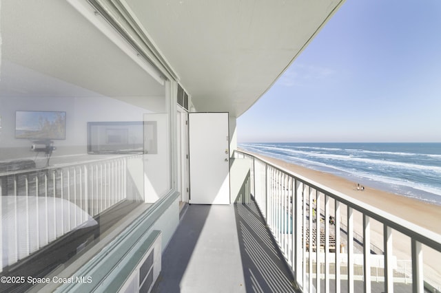 balcony featuring a beach view and a water view