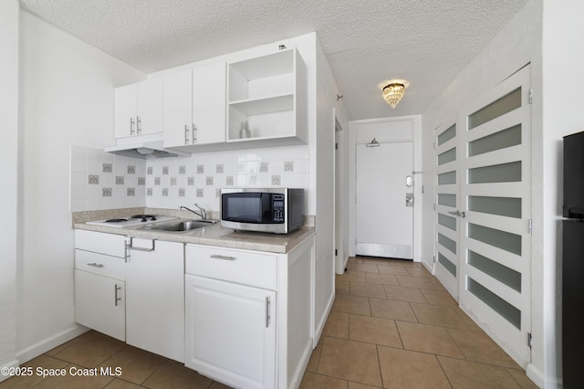 kitchen featuring light tile patterned floors, decorative backsplash, and white cabinets