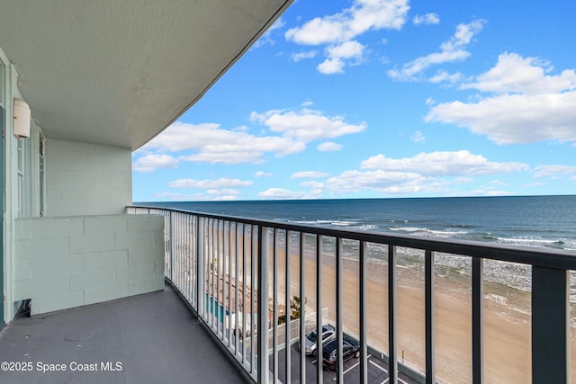 balcony featuring a view of the beach and a water view