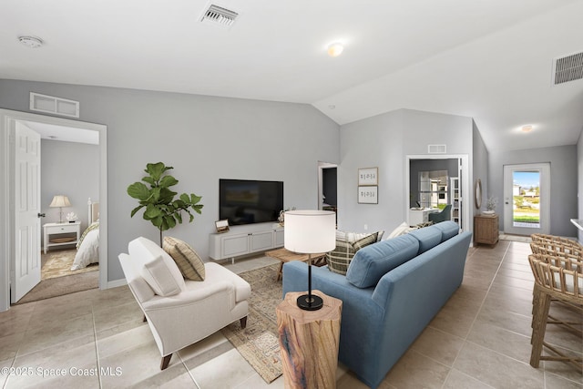 living room with lofted ceiling and light tile patterned floors