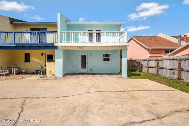 rear view of house featuring a patio and a balcony