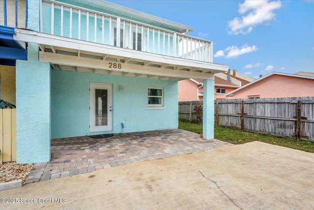 rear view of property with a patio area, a fenced backyard, and stucco siding