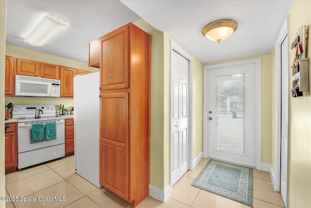 kitchen with white appliances, light tile patterned floors, baseboards, and light countertops