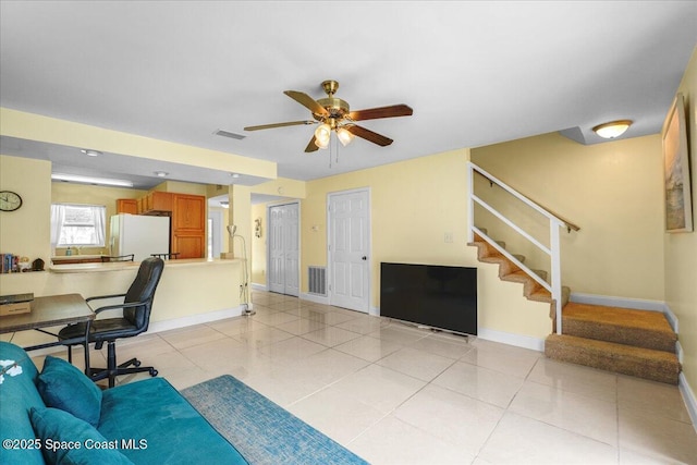 office space with visible vents, ceiling fan, baseboards, and light tile patterned floors