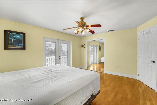 bedroom featuring access to exterior, visible vents, light wood-style floors, ceiling fan, and baseboards