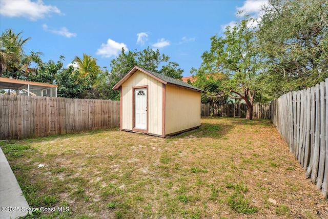 view of yard with a fenced backyard, a storage unit, and an outdoor structure