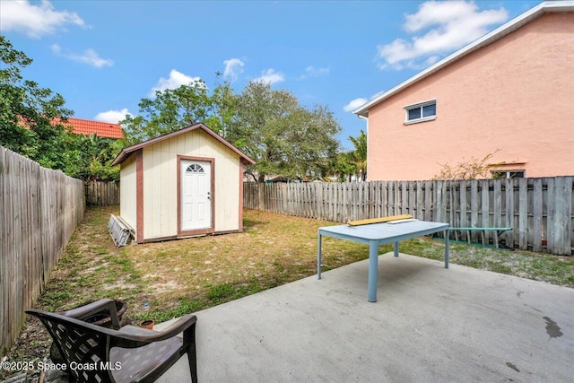 view of patio / terrace featuring a fenced backyard, a storage unit, and an outdoor structure